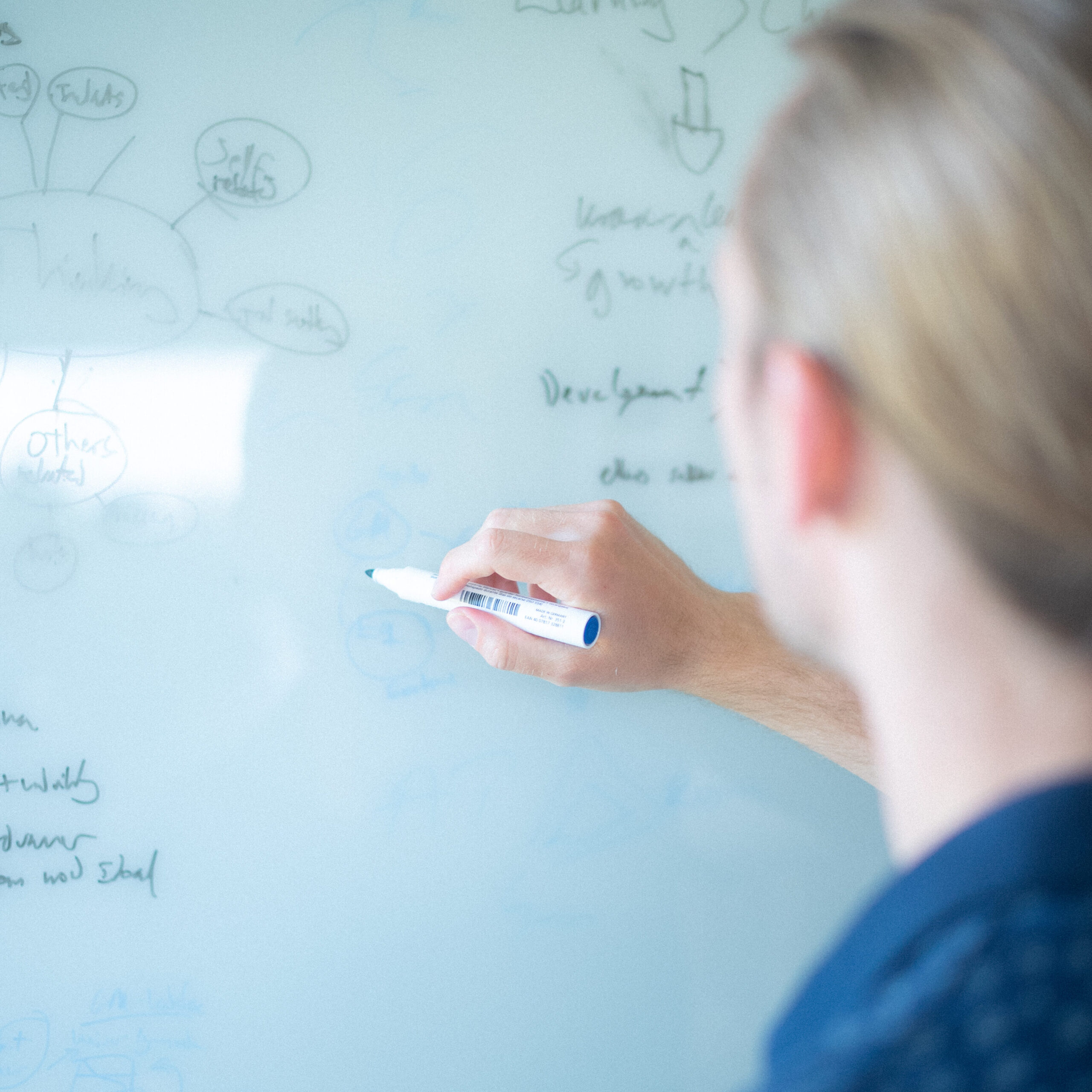 Mand skriver på whiteboard