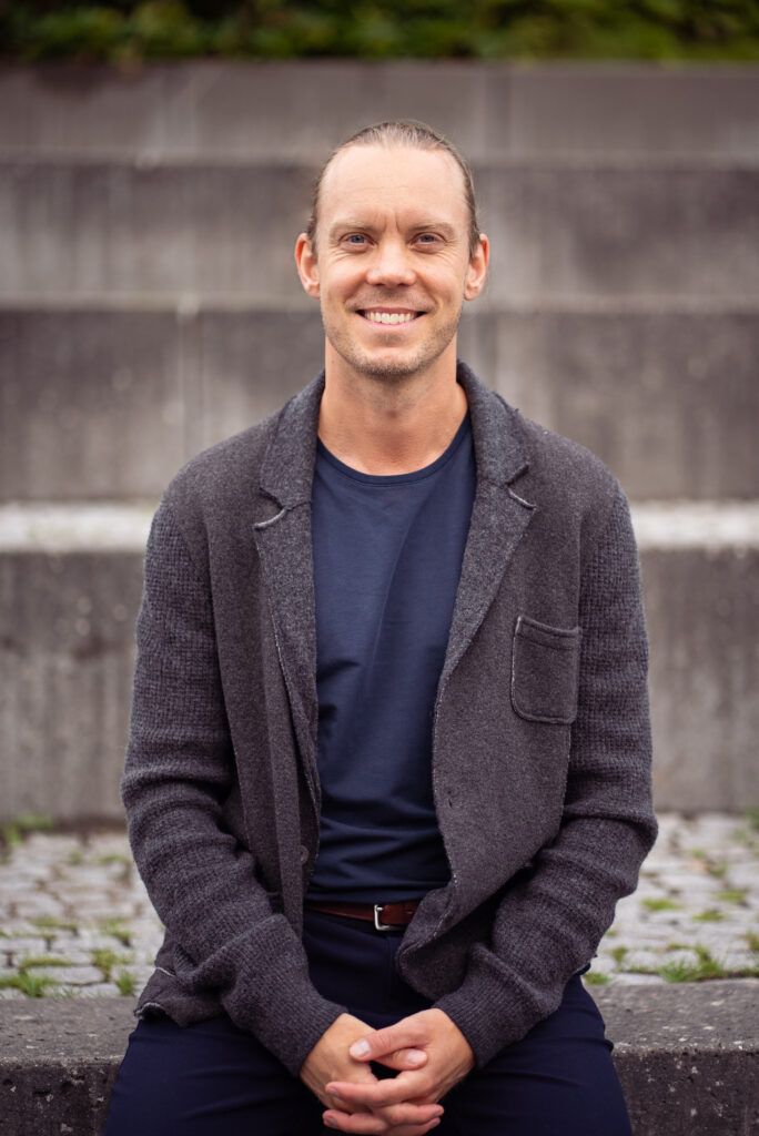 Rasmus sidder og kigger ind i kameraet.